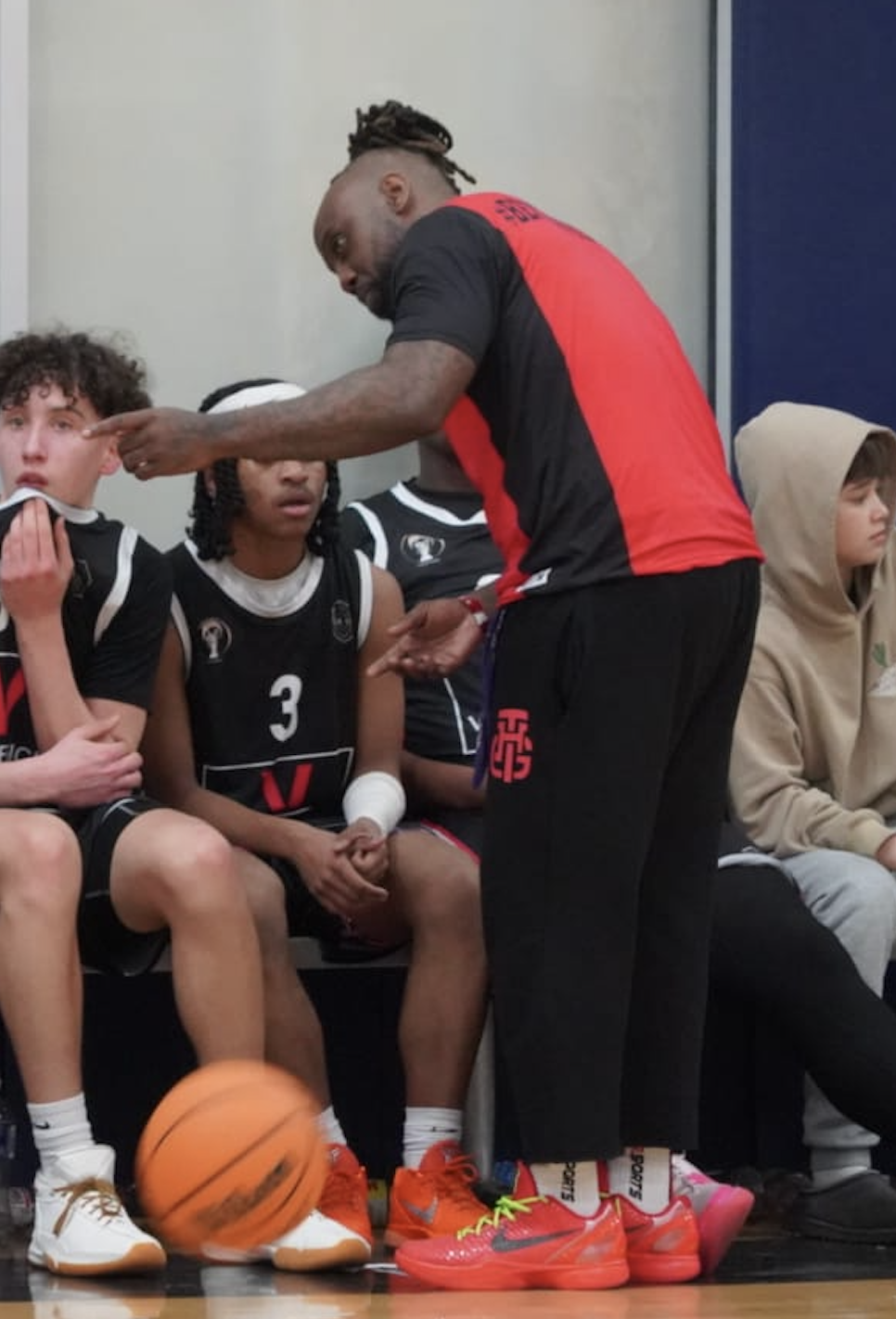 Coach Vito coaching players courtside during a game
